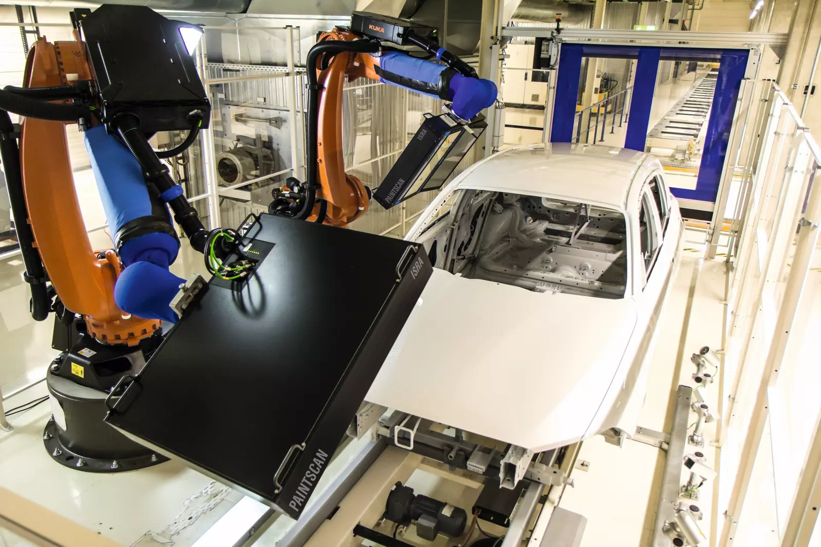 Robotic paint inspection cell scanning a painted car body on an automotive finishing line
