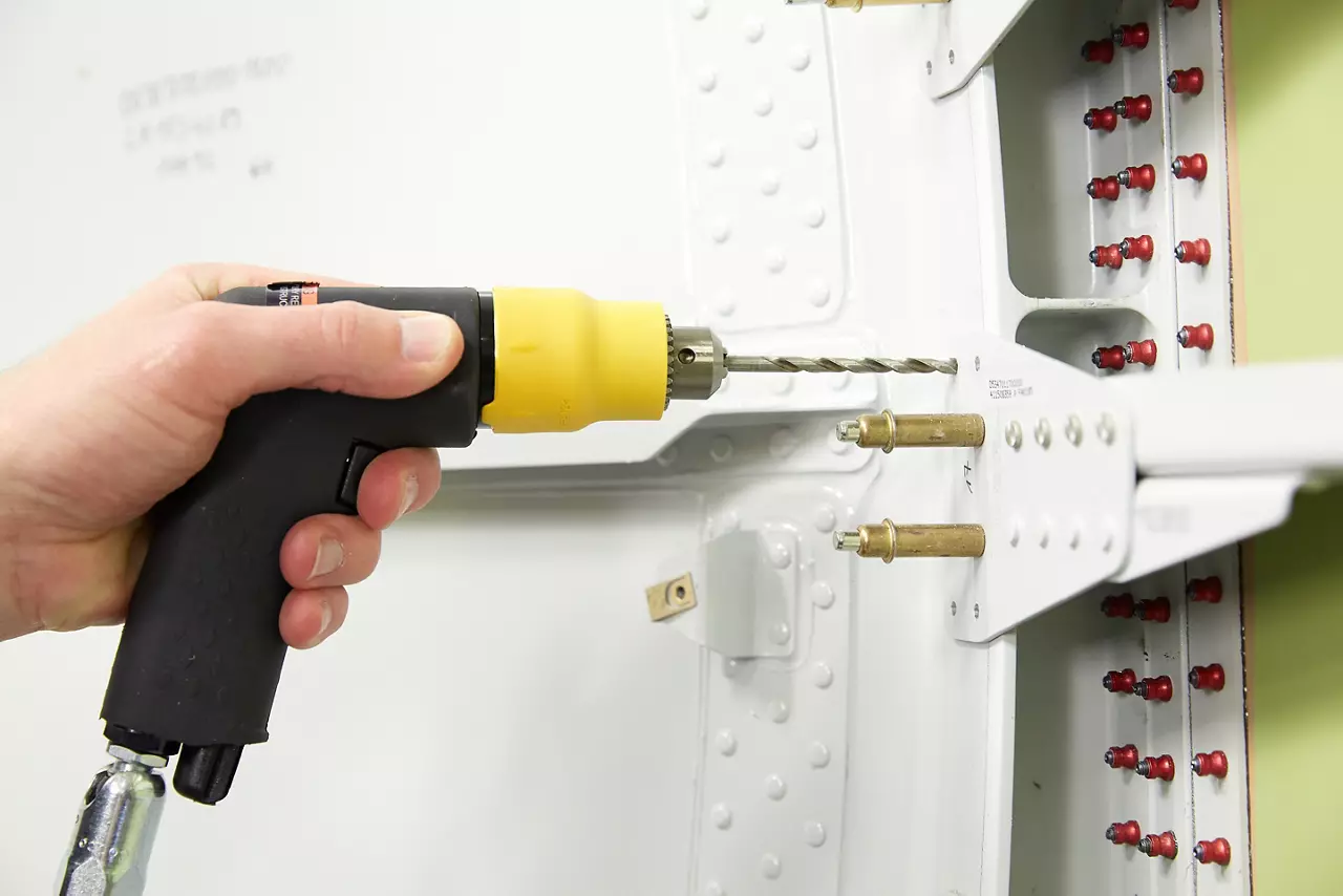 Pneumatic drill being used on an aircraft structural panel held with Cleco fasteners